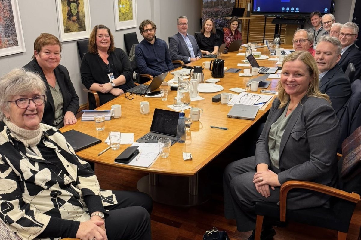 Flere personer sitter rundt et møtebord