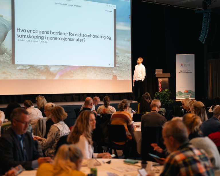 Mann står på scenen