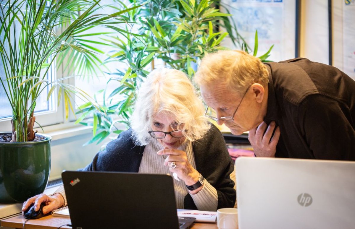 To eldre personer kikker på en pc sammen