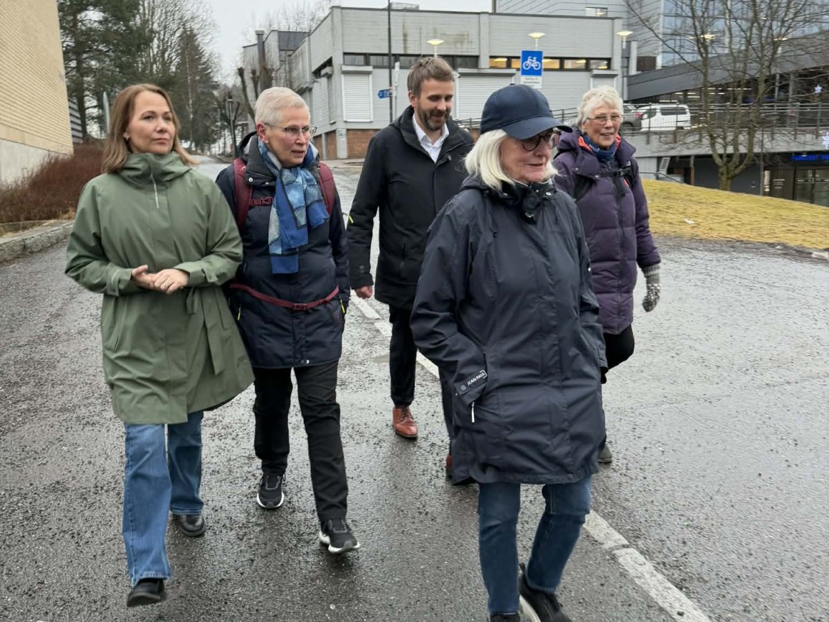 Flere personer går ute langs et fortau
