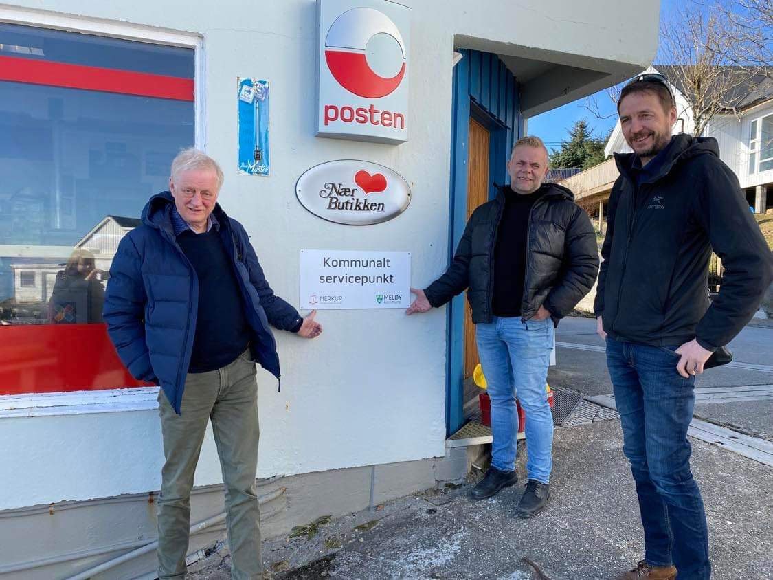 tre menn står utenfor en butikk