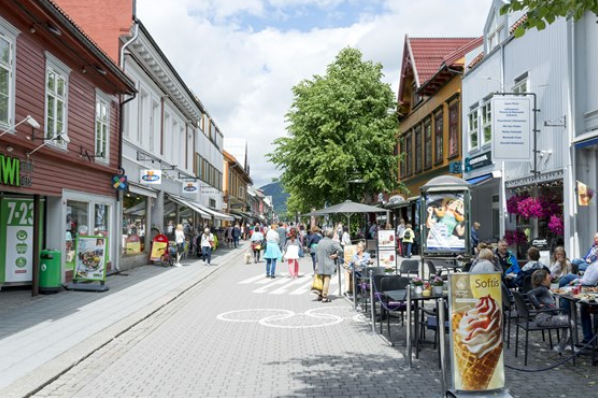 Gatebilde fra Lillehammer sentrum en sommerdag med folk i gatene og trehusbebyggelse