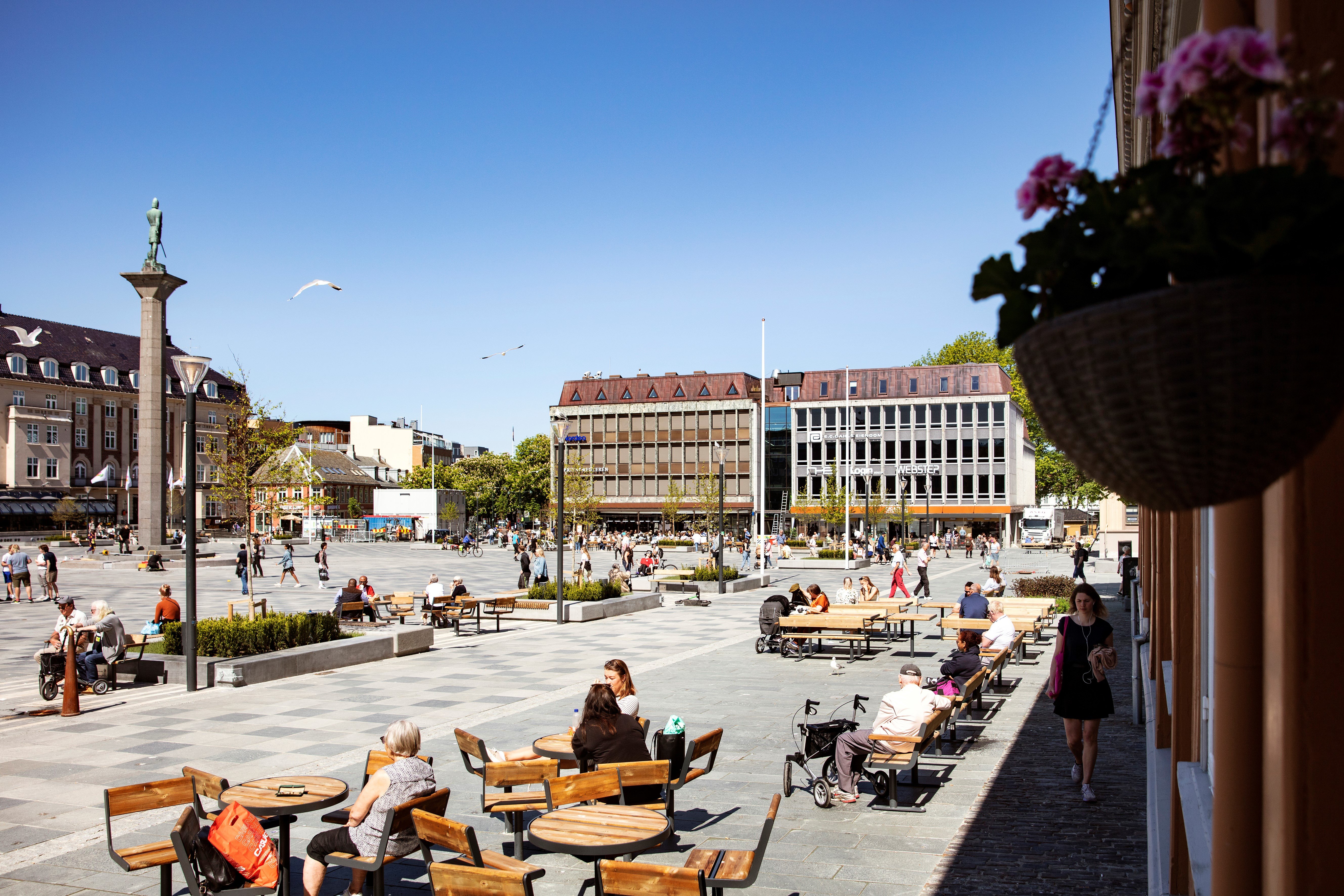 Oversiktsbilde av torvet i Trondheim med benker, blomster og masse folk