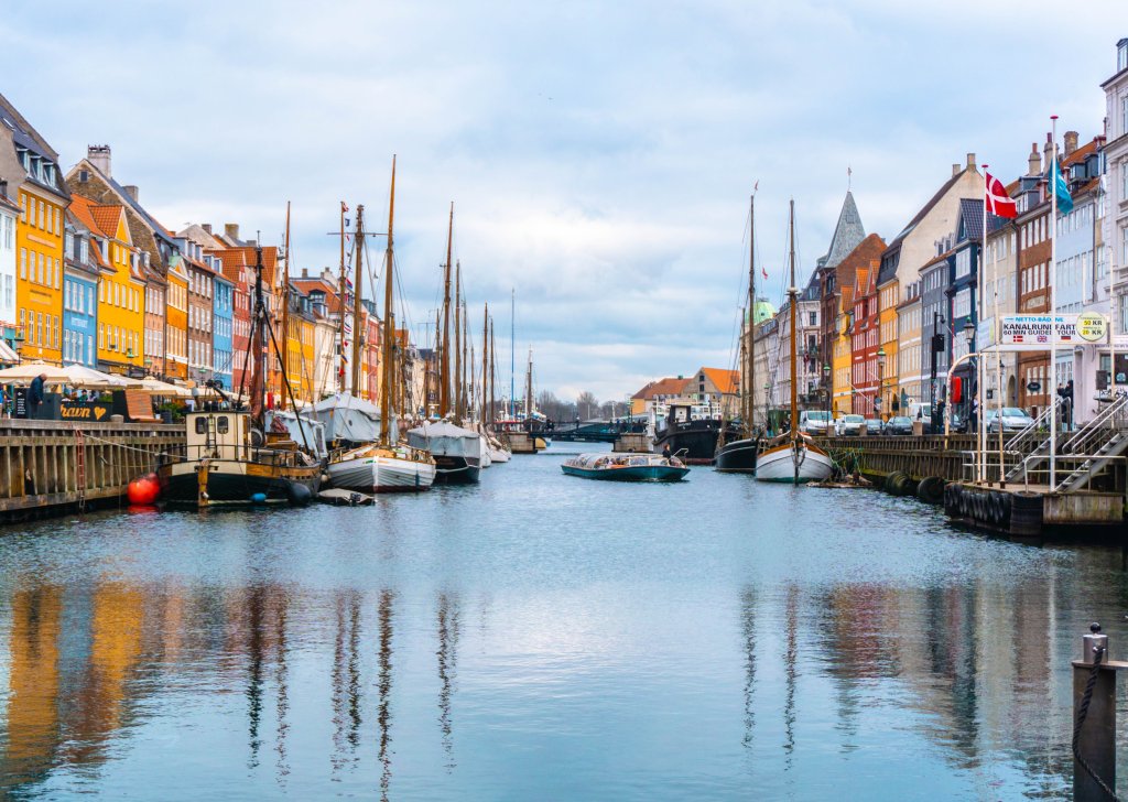 Kanalen i kobenhavn med båter og fargerike hus på hver side