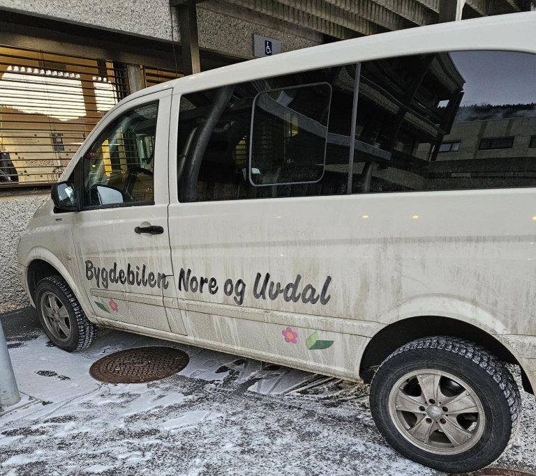 hvit minibuss parkert foran et hus 