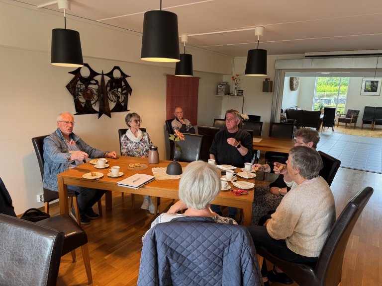 menn og damer sitter rundt et bord i felles kjøkken